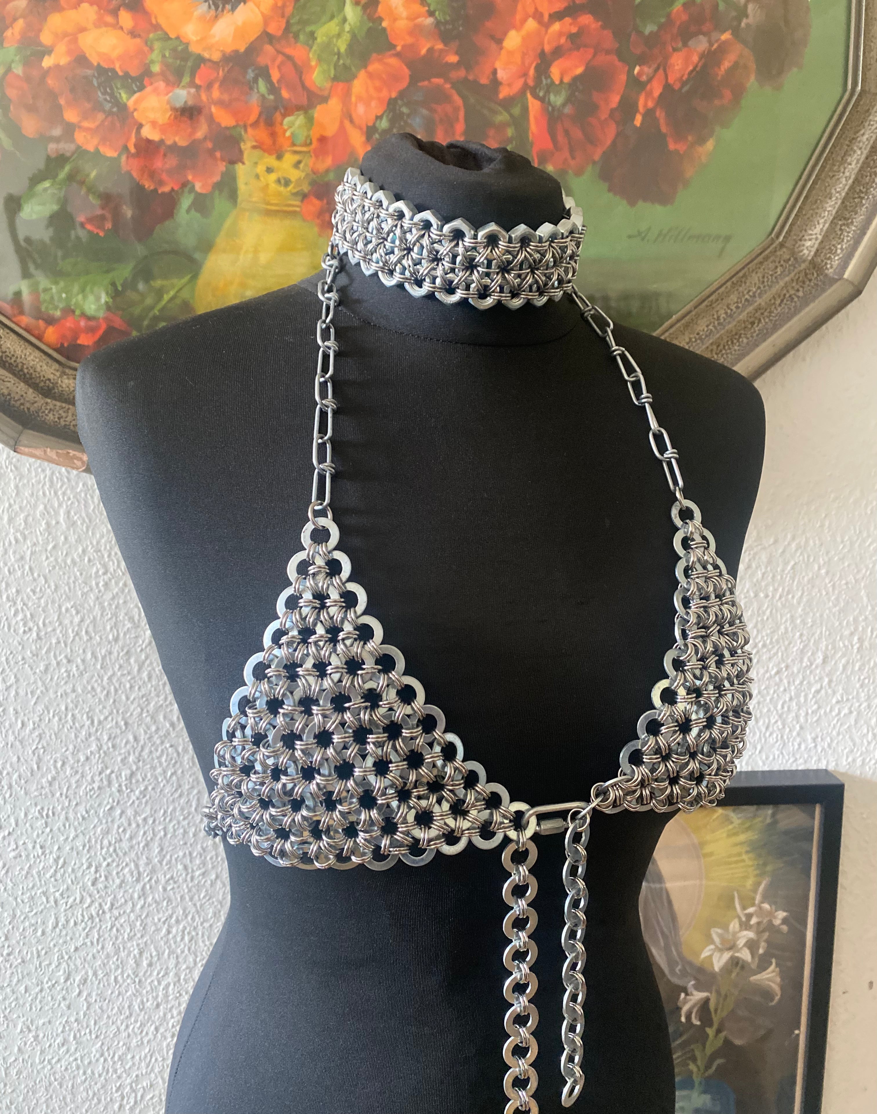 Chainmail-inspired choker made from real stainless steel industrial screws, displayed on a puppet; doll also wearing an industrial chain bra crafted from genuine screw details, creating a heavy, statement look.