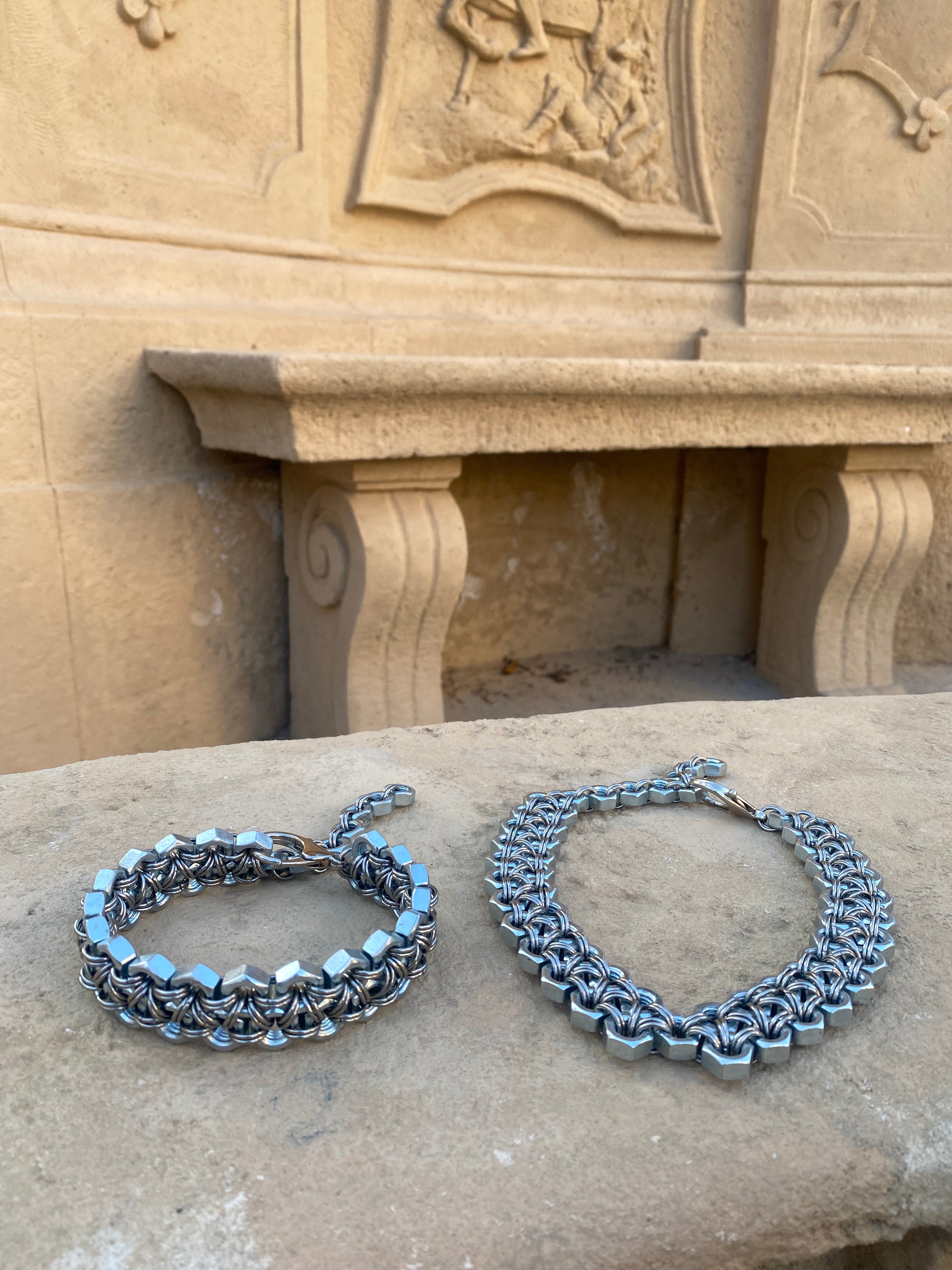 Heavy-duty industrial chainmail necklaces made from stainless steel screws and chainmail, shining in a beautiful gothic environment.