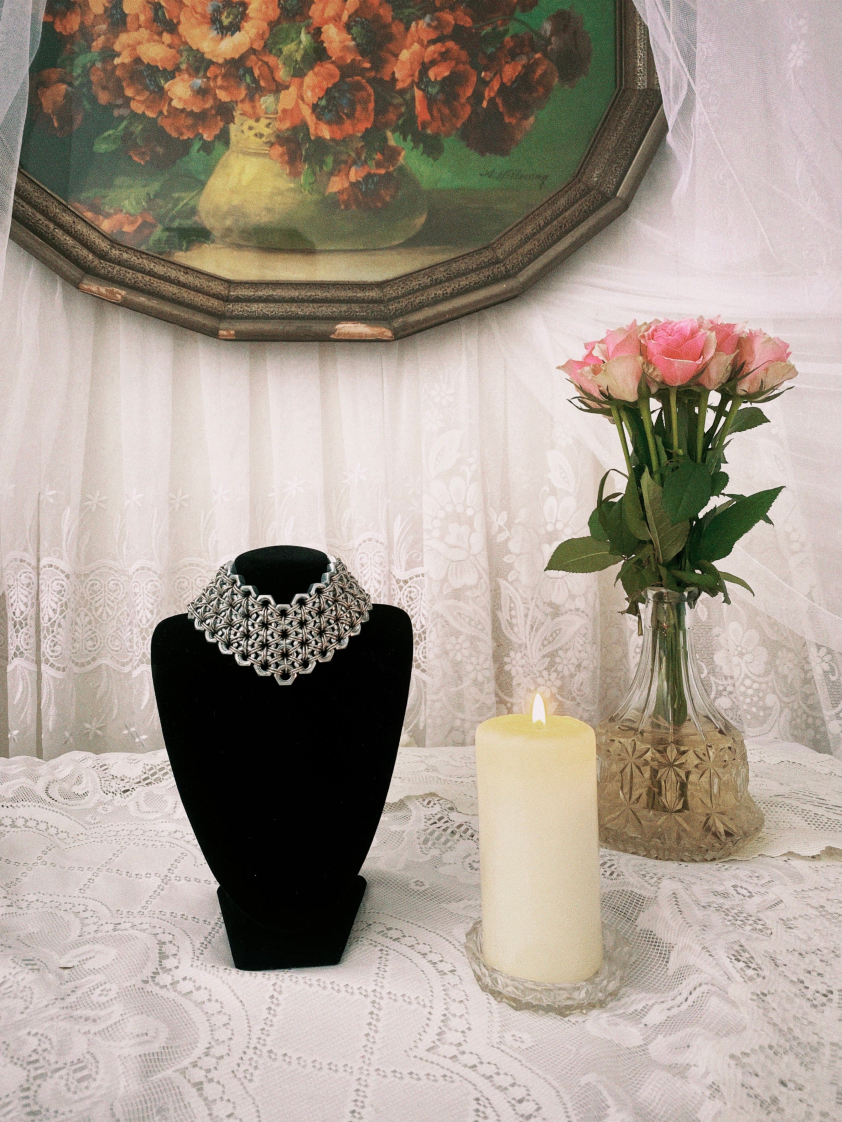 Heavy-duty statement chainmail choker with a silver shine, presented in a gothic setting with white lace and dried flowers; handmade in Berlin from stainless steel.