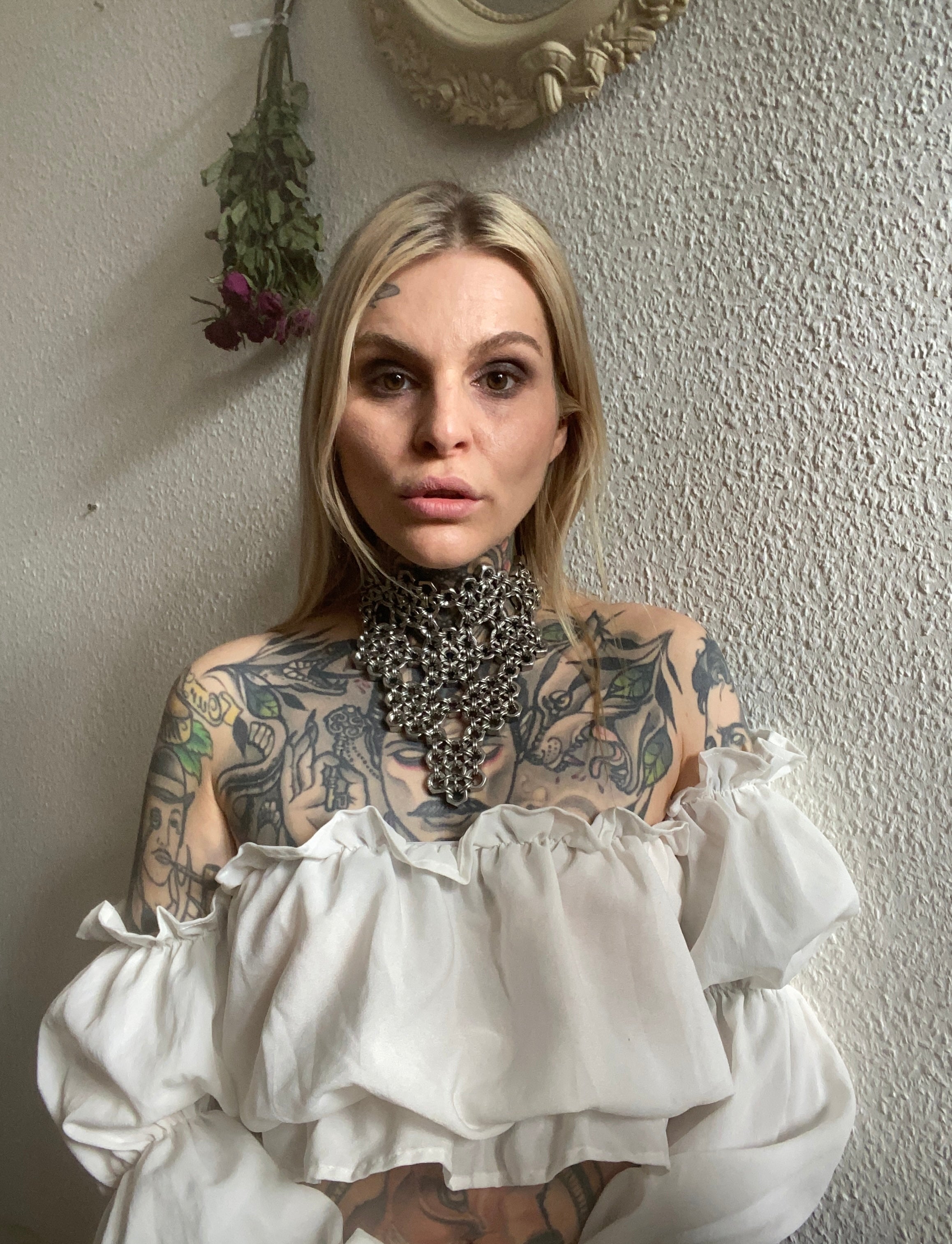 Blonde tattooed model wearing handcrafted floral chainmail necklace with silver shine, made in Berlin from stainless steel. Perfect for alternative fashion inspo or for alternative fahion outfits.