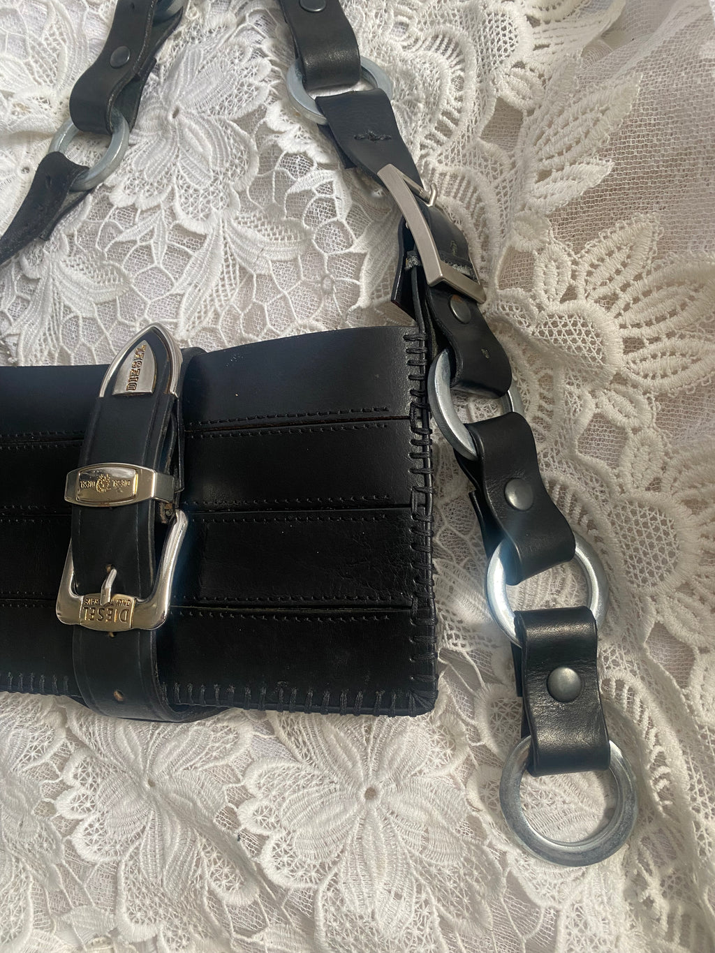 Close-up of handbag with shiny authentic ring-screw handle, a bold avant-garde statement accessory made from upcycled leather for sustainable fashion. Designed for alternative fashion lovers to make every outfit stand out.
