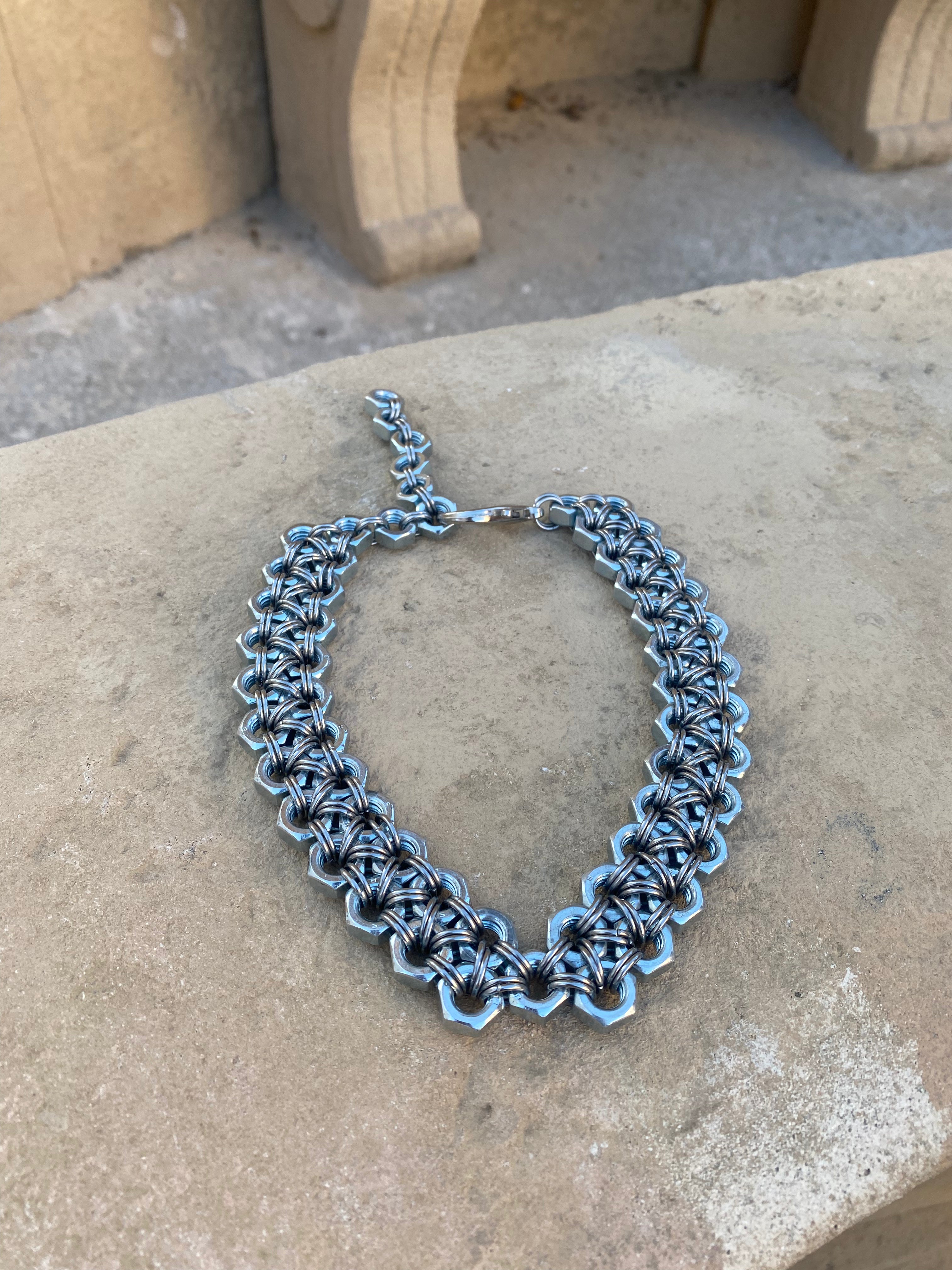 Industrial heavy silver statement necklace made from stainless steel screws and chainmail, photographed on rocks for the ultimate metallic shine.