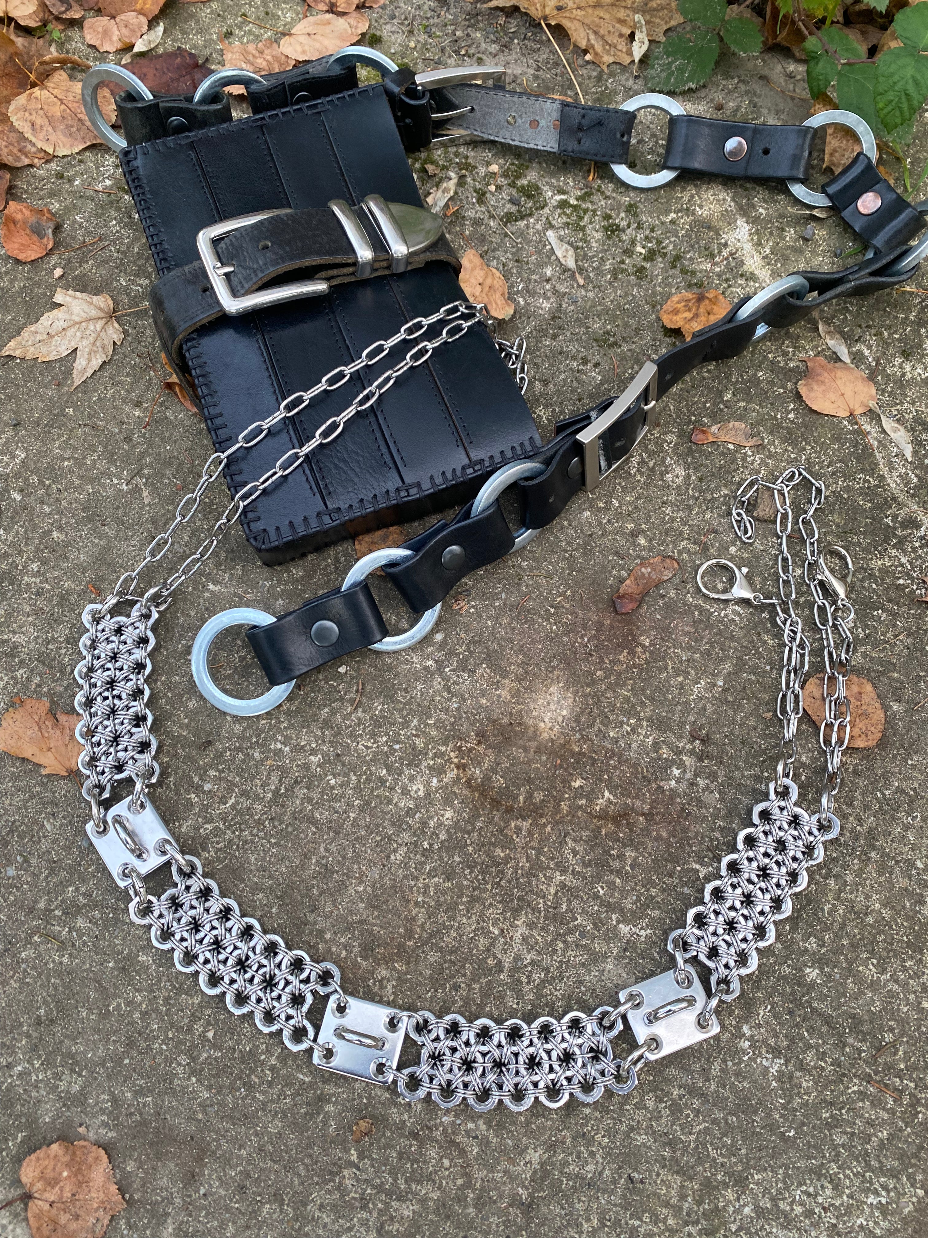 repurposed leather handcrafted bag laying on rock with heavy duty chainmail belt made from industrial screws and chainmails